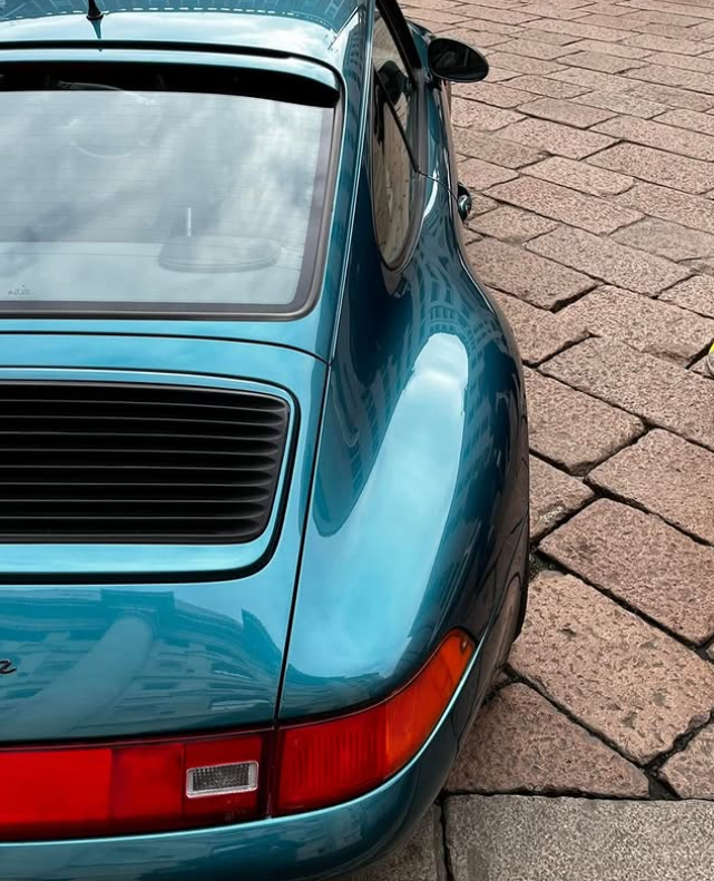 Blue Porsche Carrera 911 detail on pavement