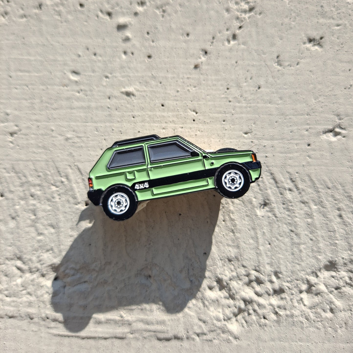 Fiat Panda 4x4 mint enamel pin on cement background