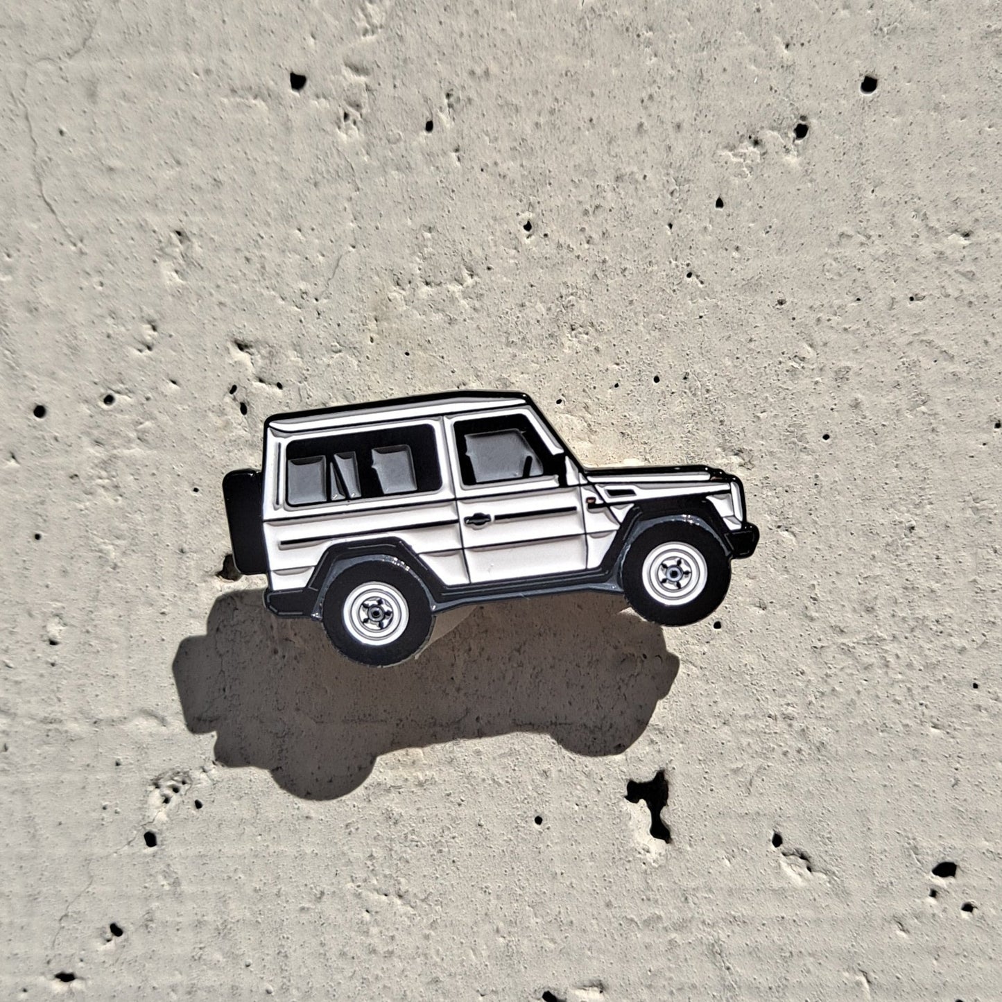 Mercedes-Benz W460 white enamel pin on cement background