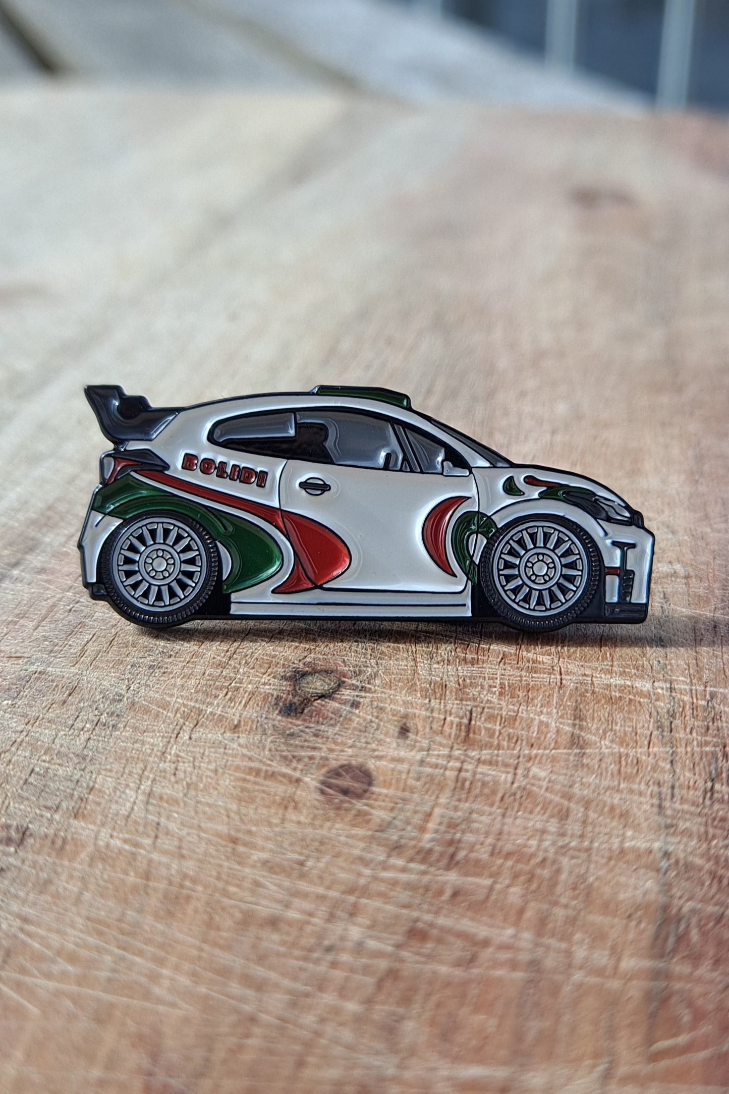 Toyota Yaris GR enamel pin on wooden surface