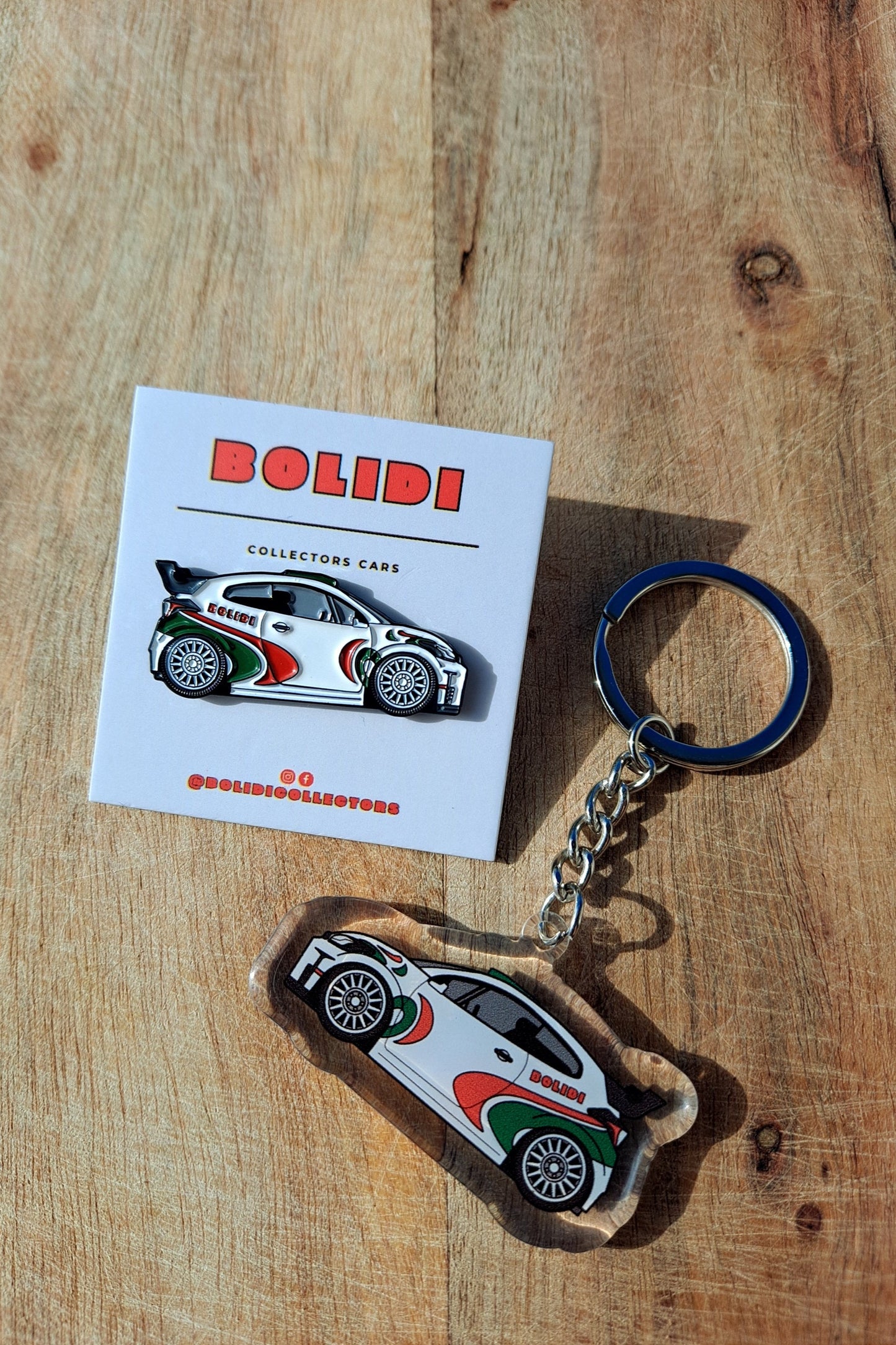 Toyota Yaris GR enamel pin and keychain on wooden surface